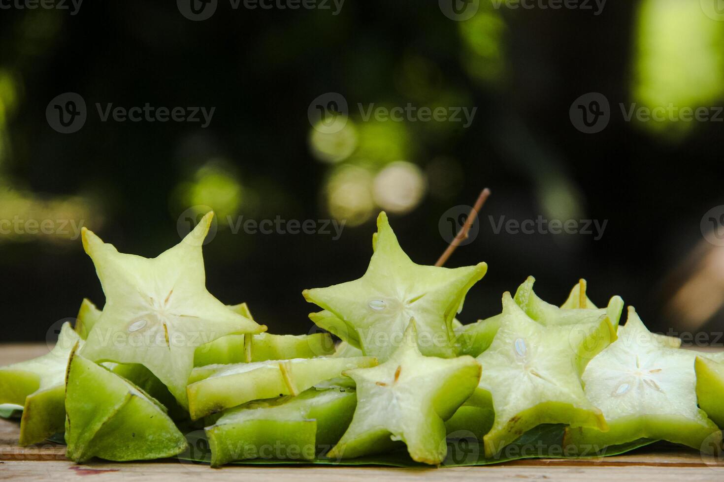 Carambola fruit with slice of star fruit on wooden table and natural background photo