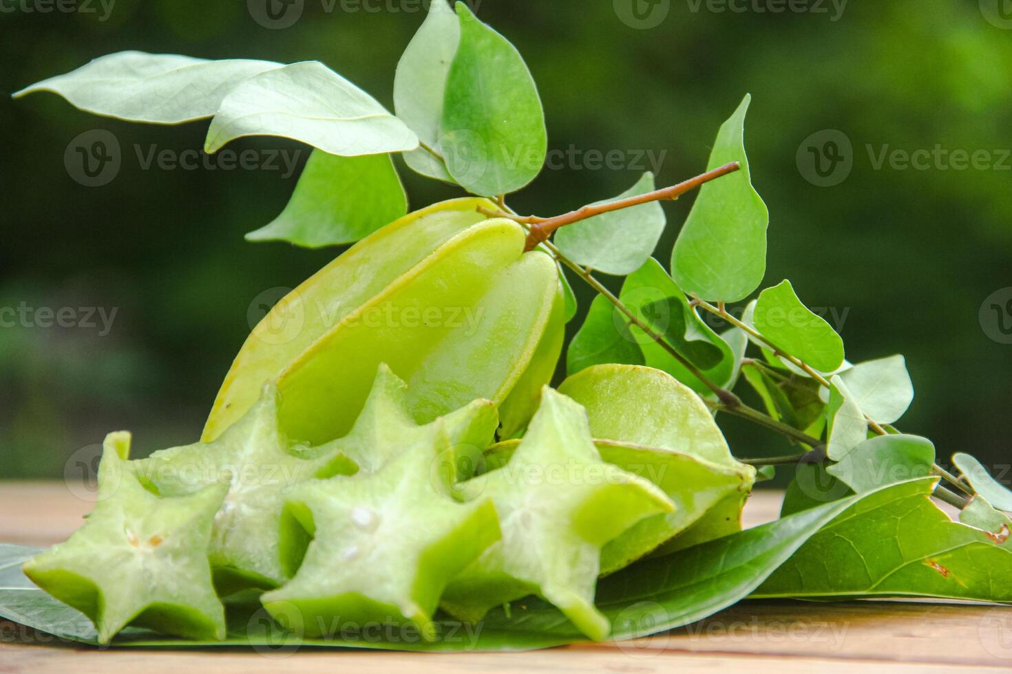 Carambola fruit with slice of star fruit on wooden table and natural background photo