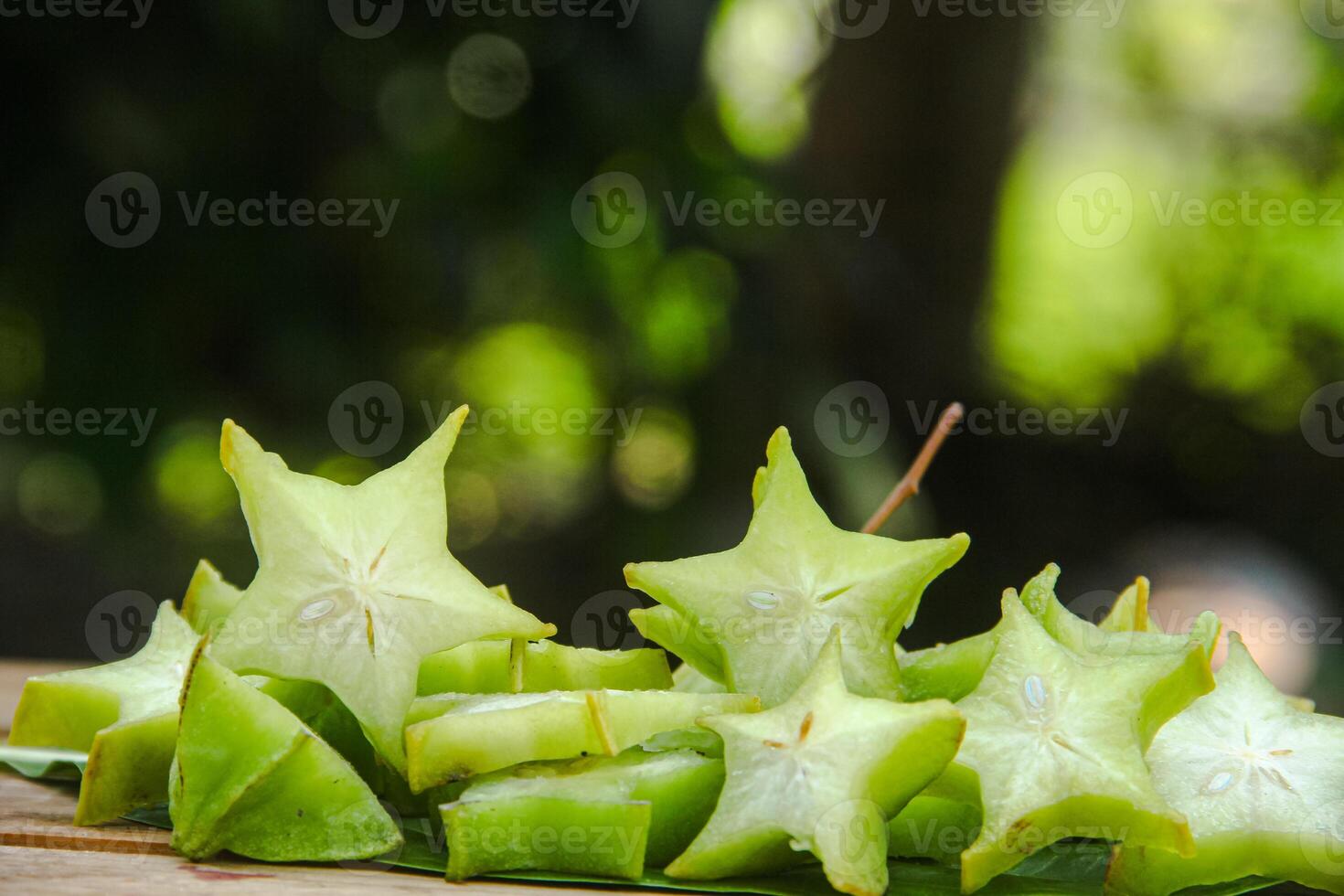 Carambola fruit with slice of star fruit on wooden table and natural background photo