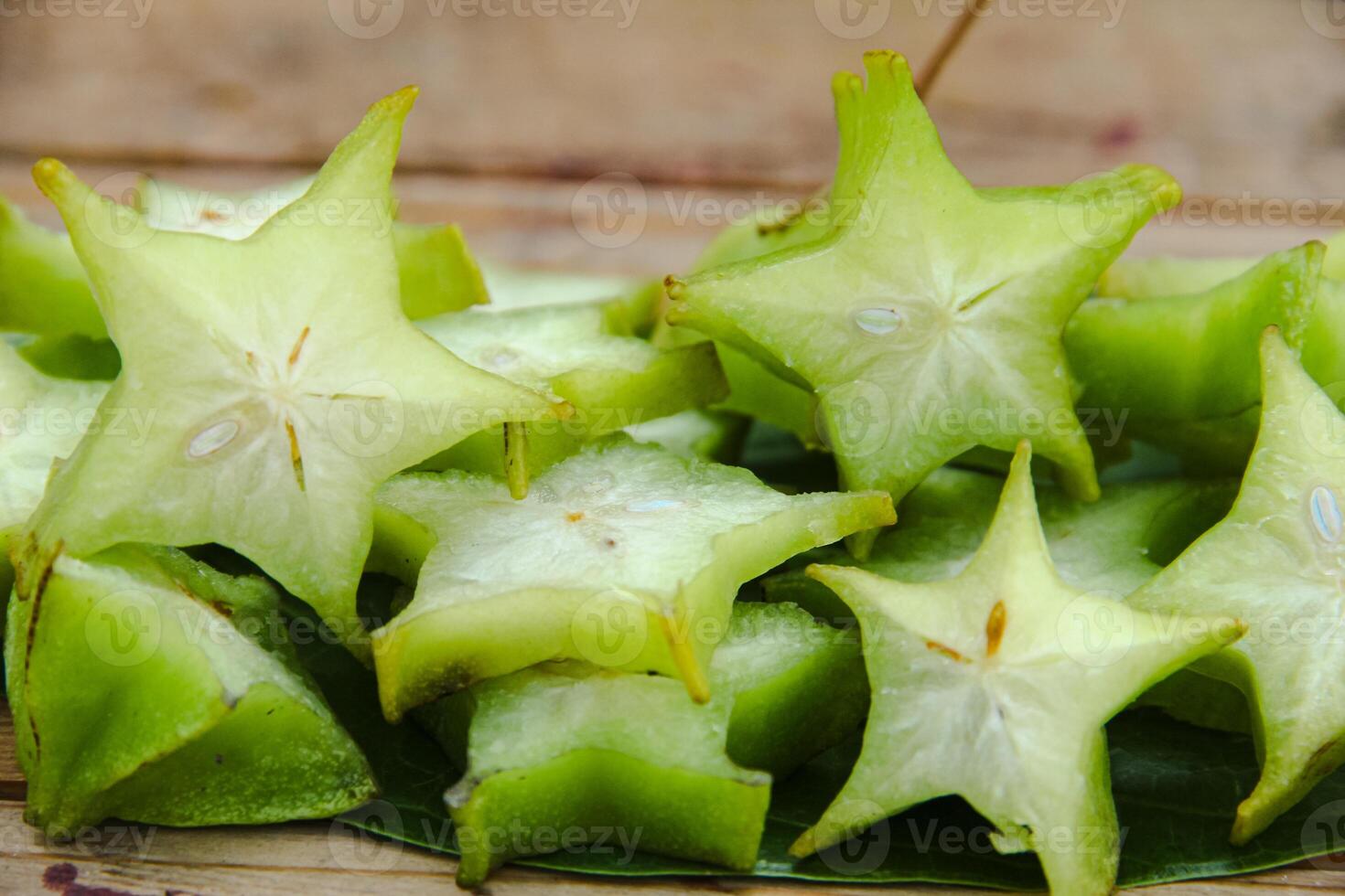 Carambola fruit with slice of star fruit on a wooden table photo