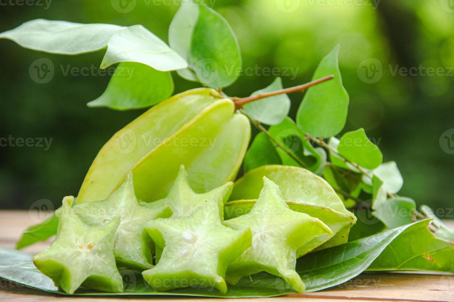 Carambola fruit with slice of star fruit on wooden table and natural background photo
