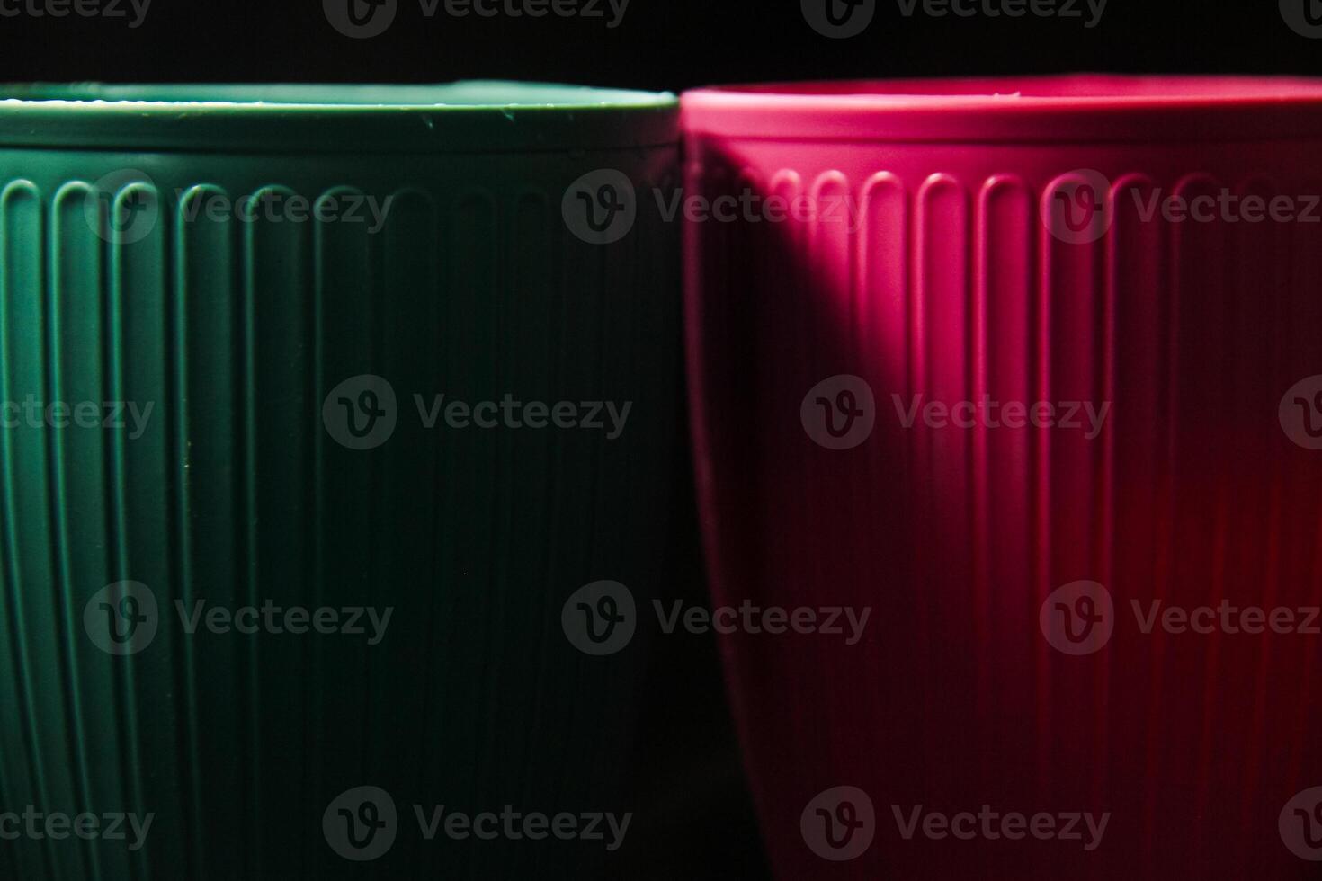 Colored plastic cups on a black background photo