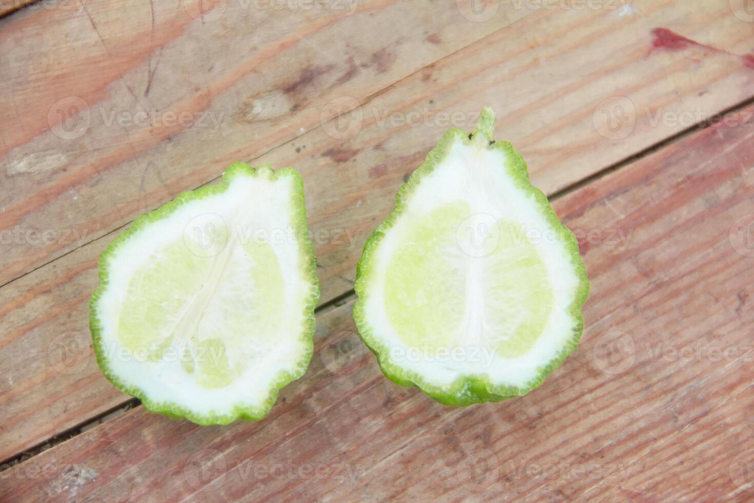 Fresh bergamot or sliced kaffir lime fruit with isolated on traditional wooden table photo