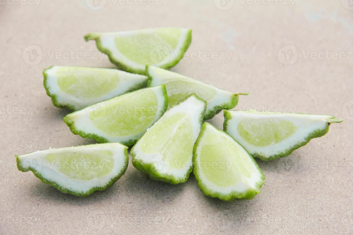 Fresh bergamot or sliced kaffir lime fruit with isolated on traditional wooden table photo