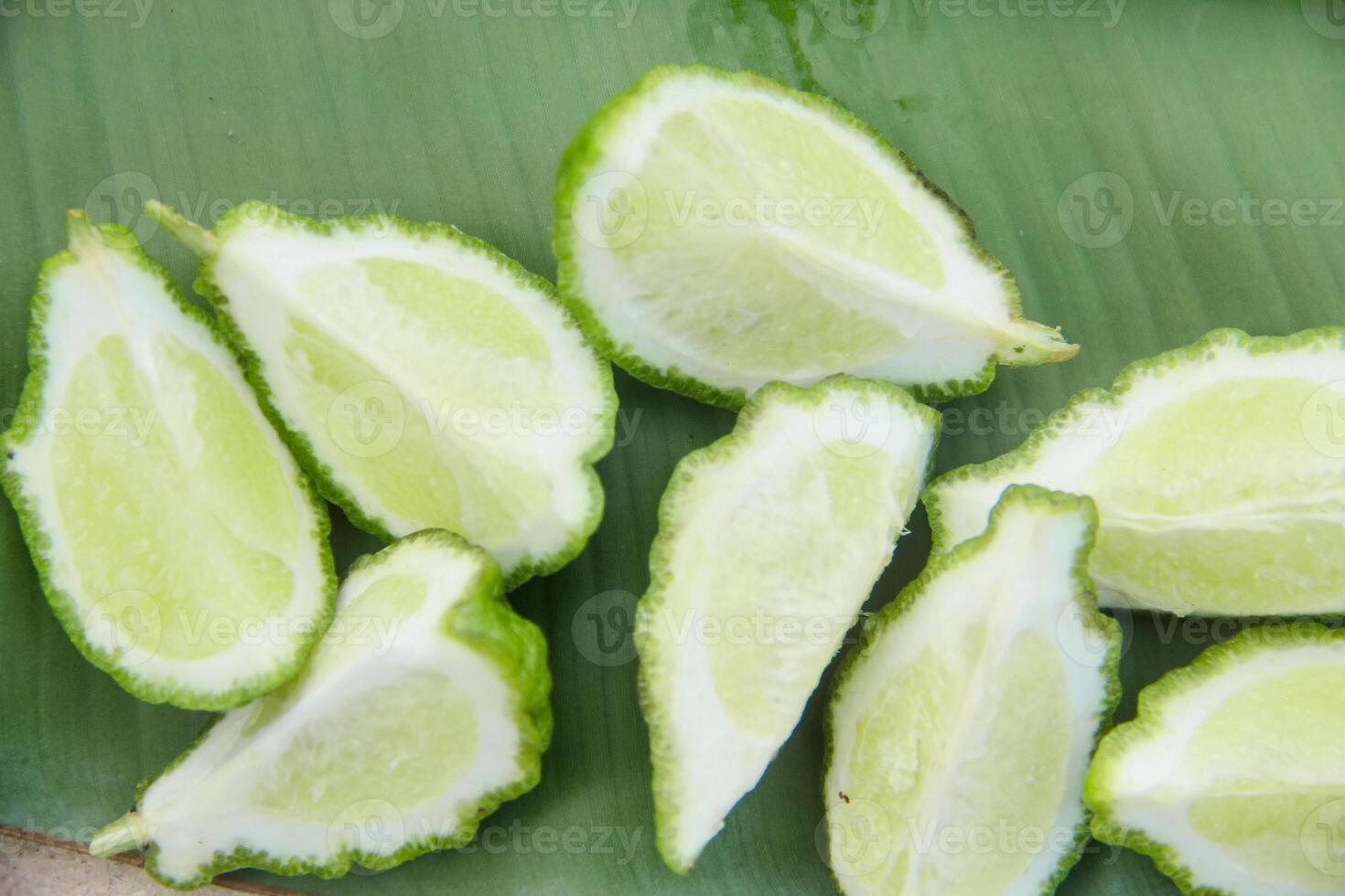 Fresh bergamot or sliced kaffir lime fruit with isolated on traditional wooden table photo