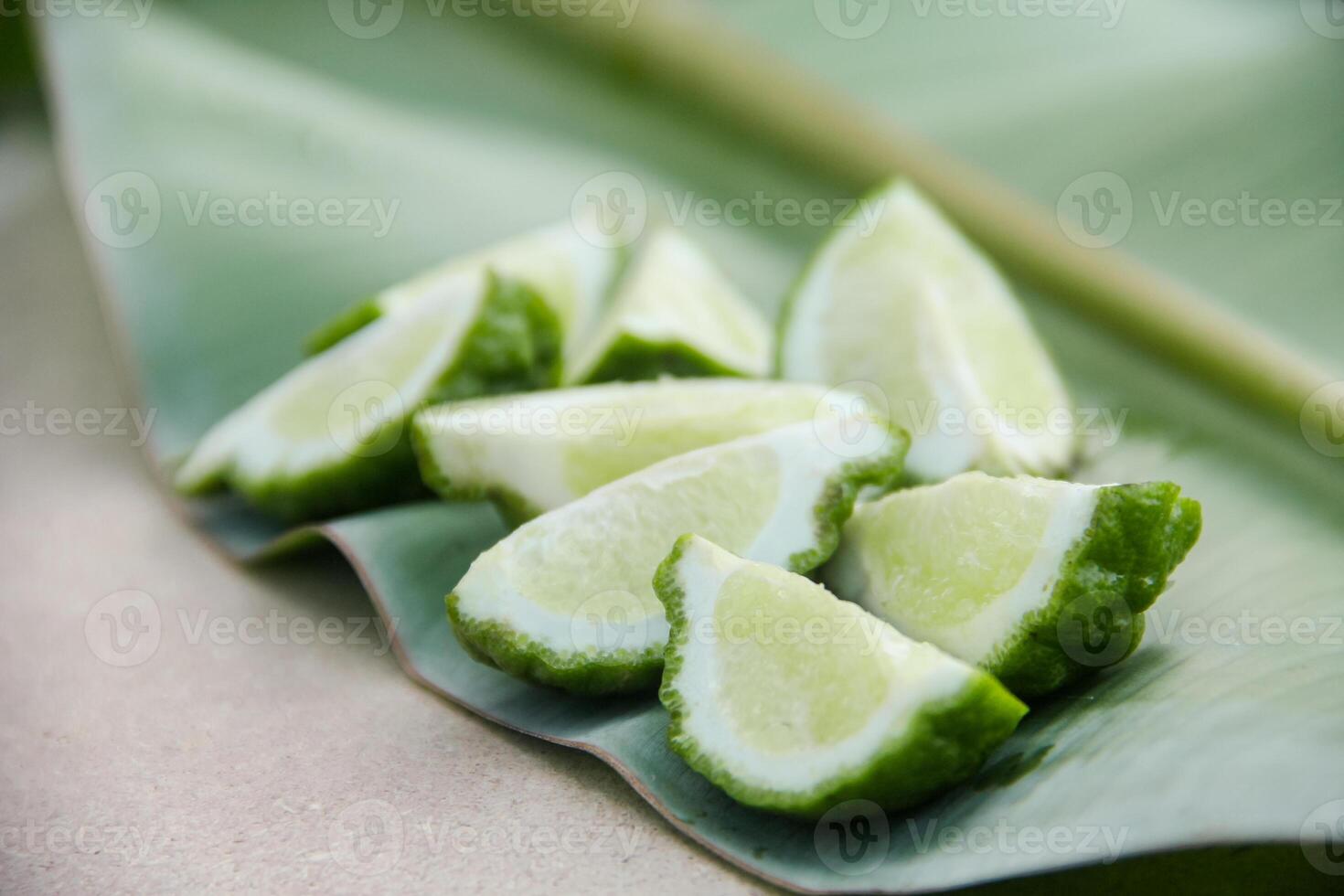 Fresh bergamot or sliced kaffir lime fruit with isolated on traditional wooden table photo