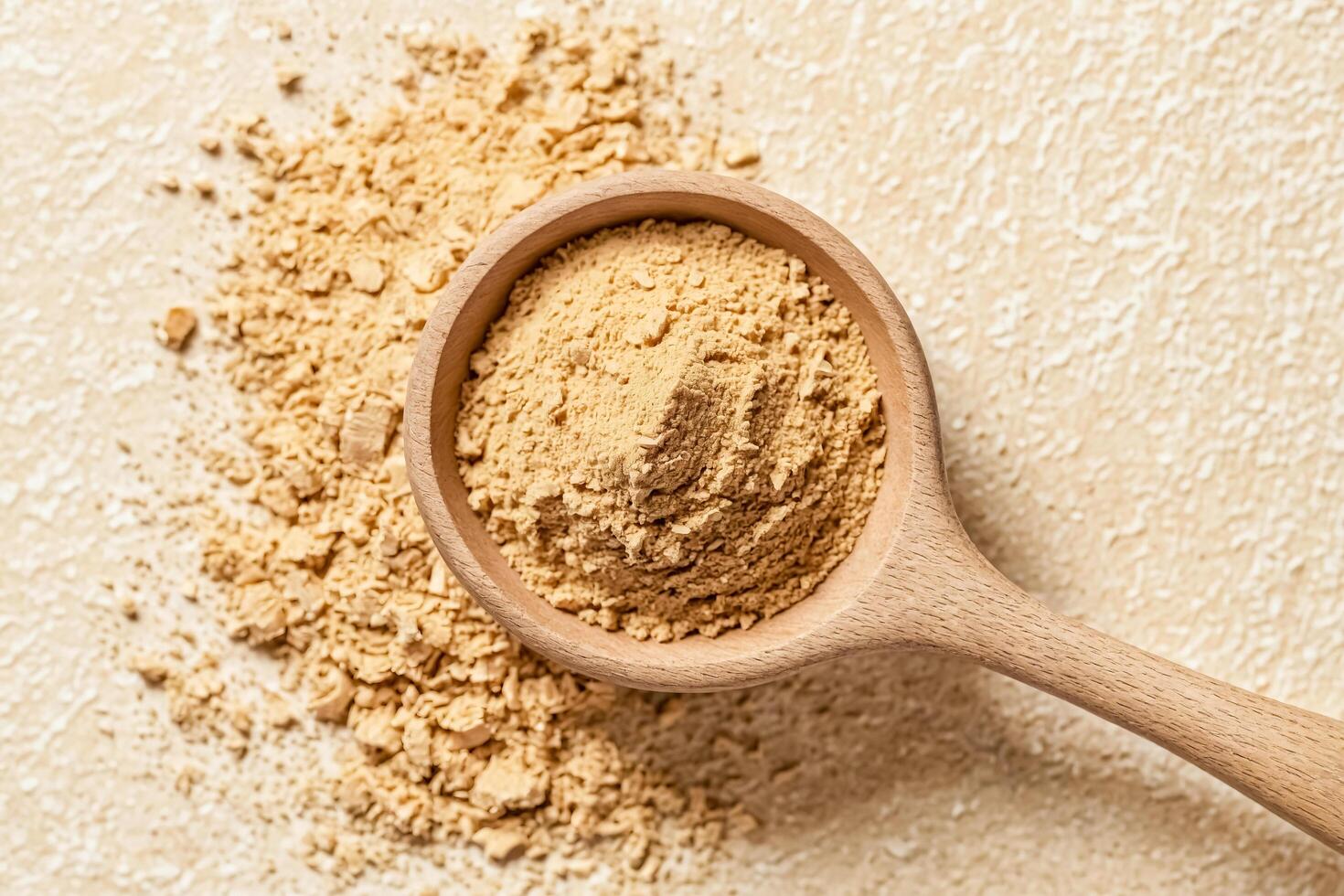 Close up of a wooden spoon filled with ground ginger photo