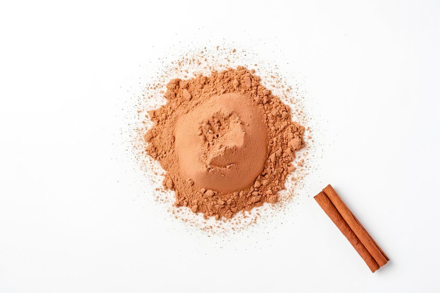 Cinnamon powder and sticks on a white background photo