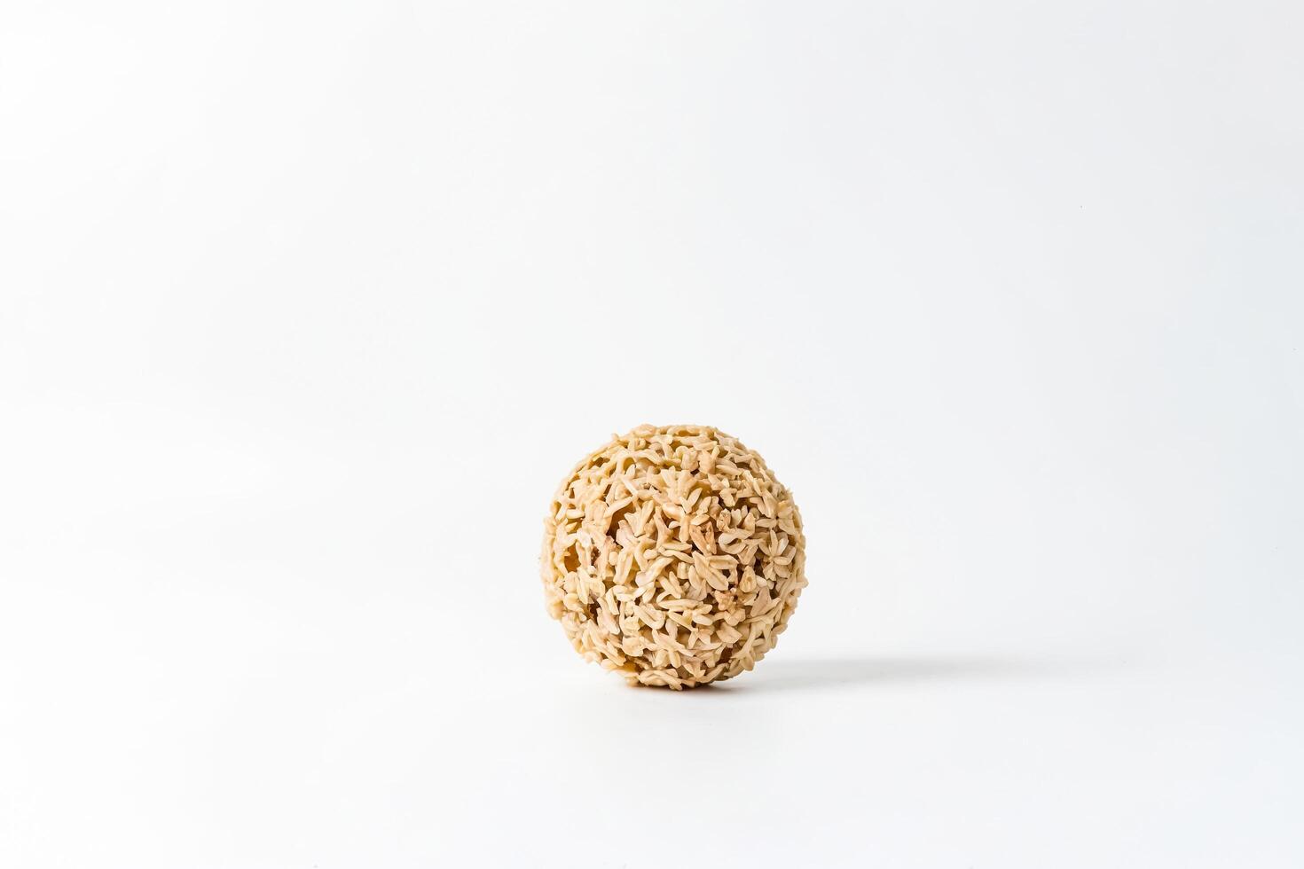 Close-up of a Small, Beige, Round, Textured Object on a White Background photo