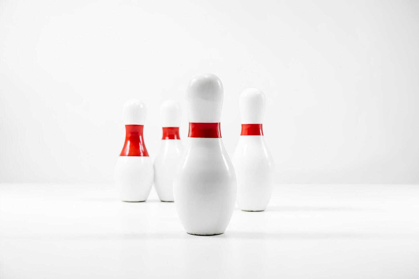 White Bowling Pins with Red Stripes on White Background photo