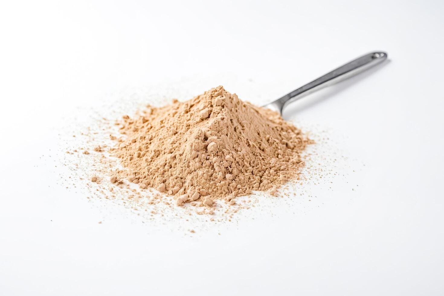 Brown powder with metal spoon on white background photo