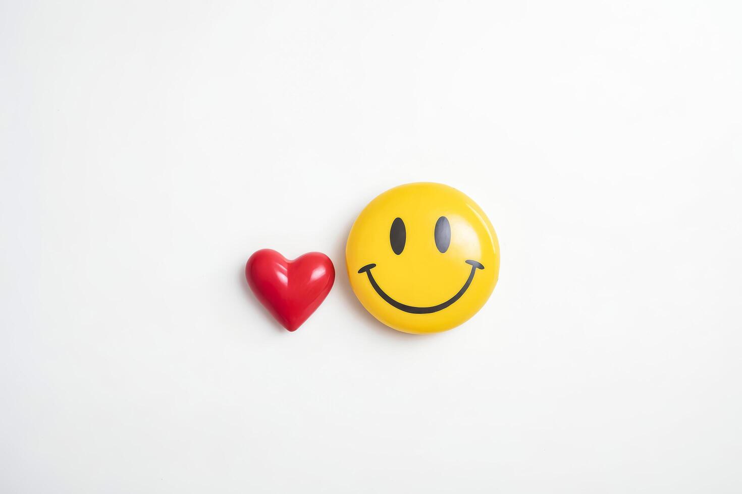 Simple smiley face and red heart on white background photo