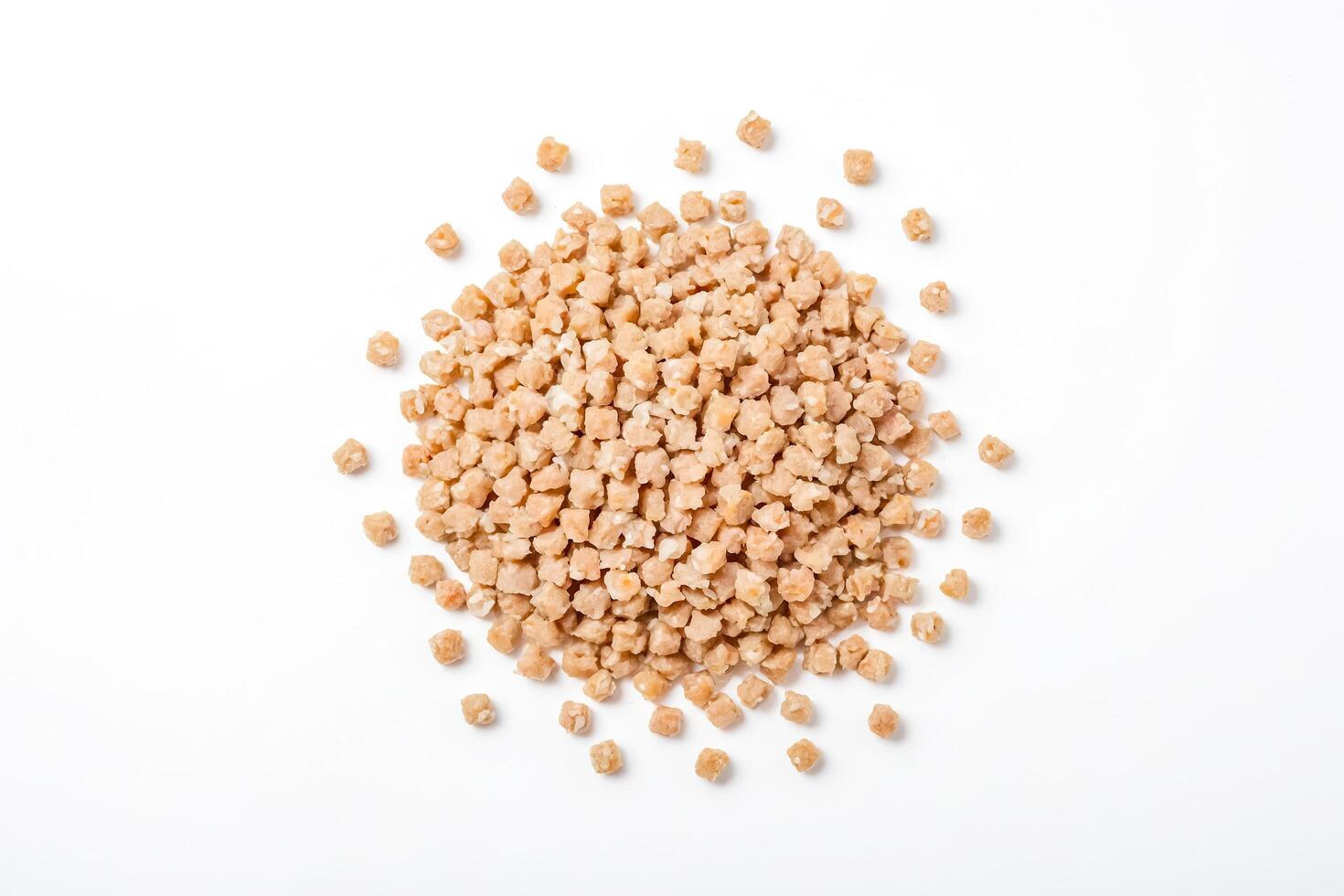 Close-up of a pile of small, light brown, square-shaped food items isolated on a white background. photo