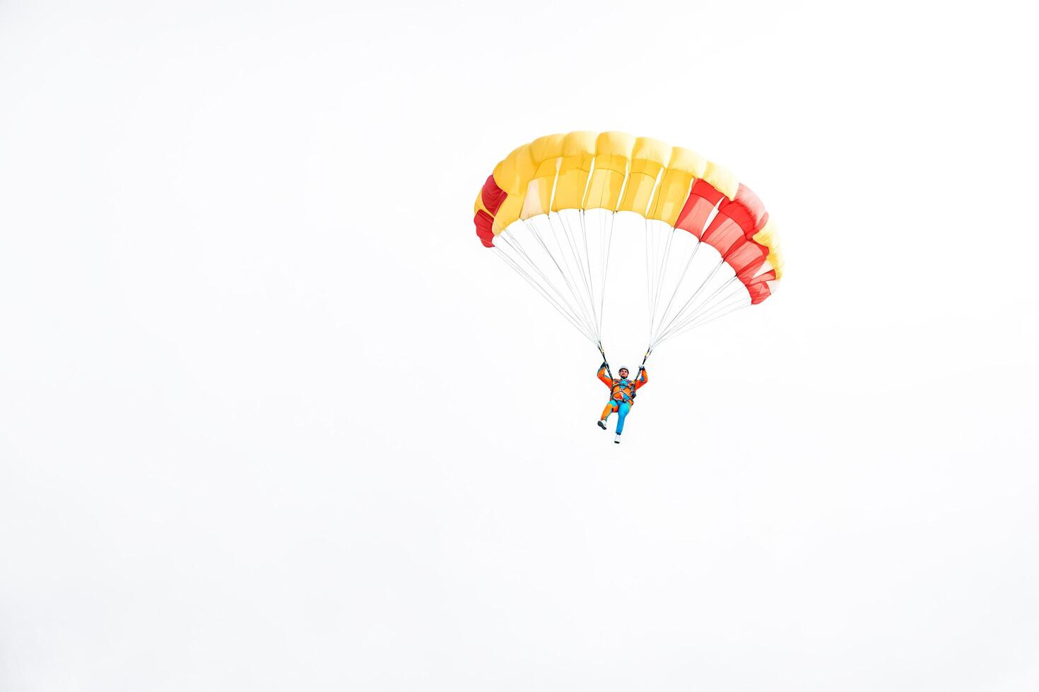 Skydiver with colorful parachute descends towards the earth photo