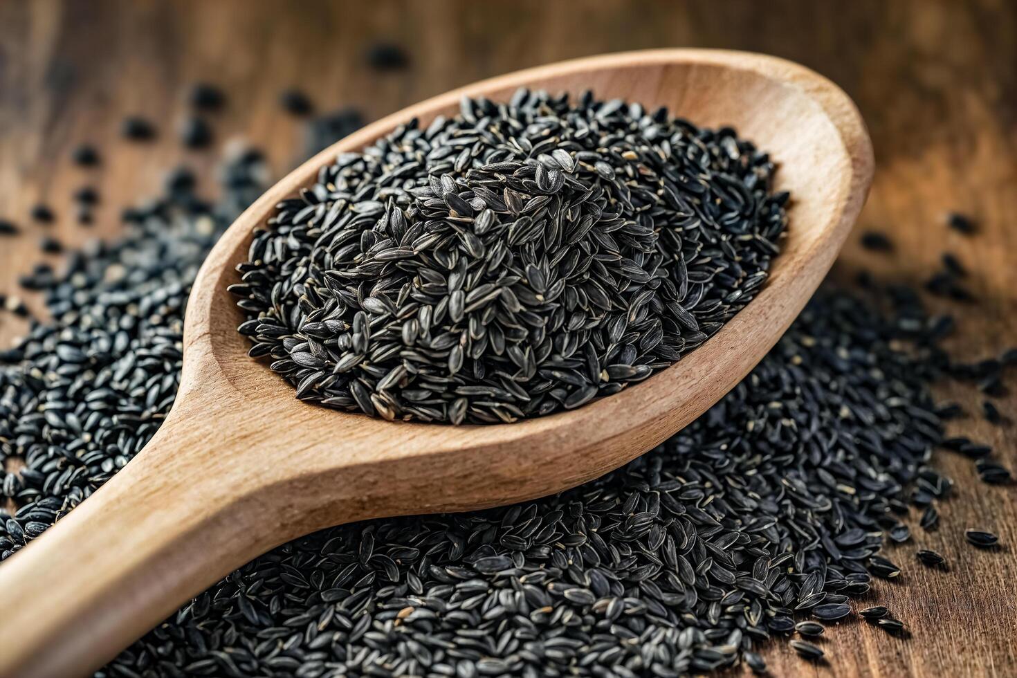Black Sunflower Seeds in Wooden Spoon photo