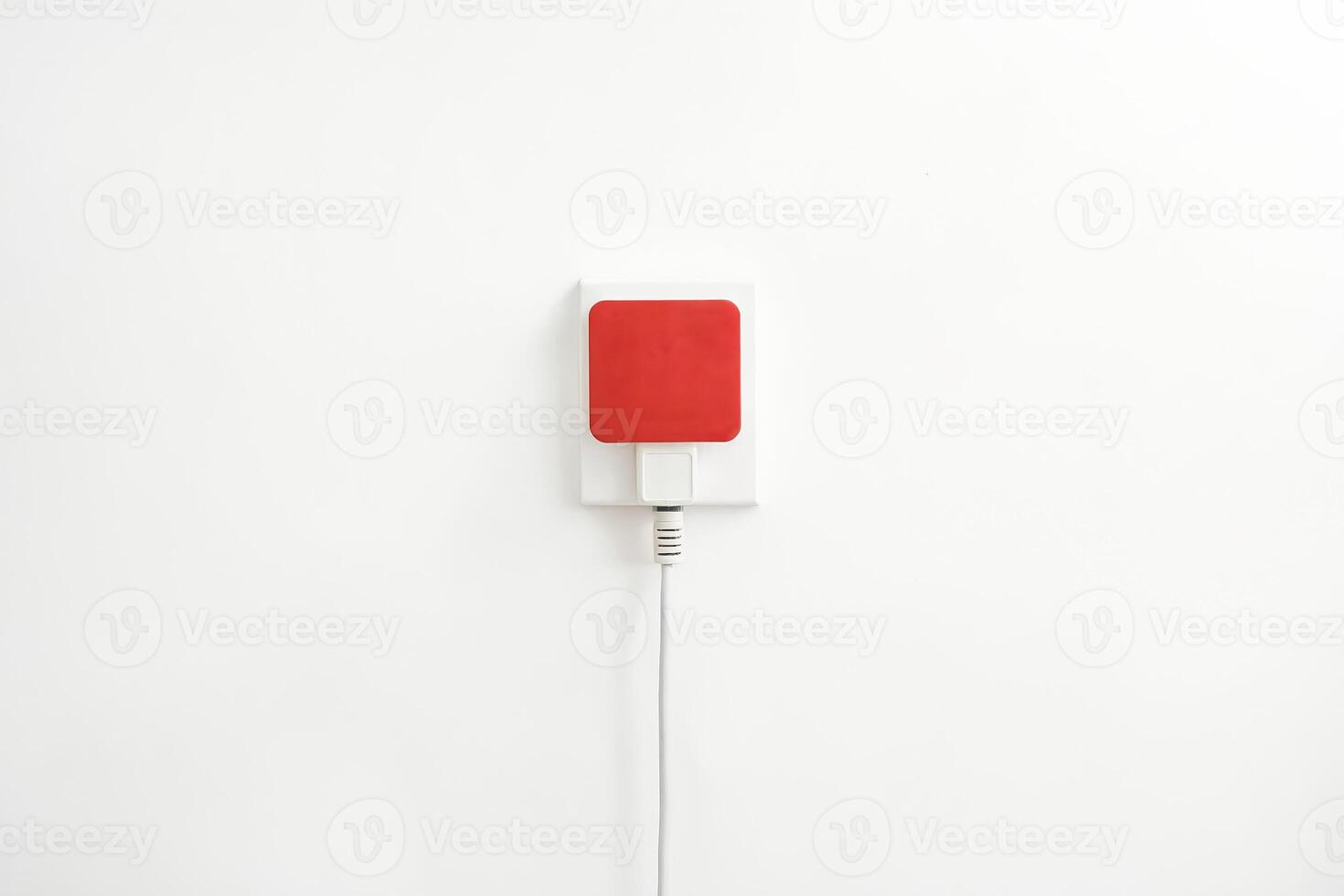 Red Power Adapter Plugged into a White Outlet photo