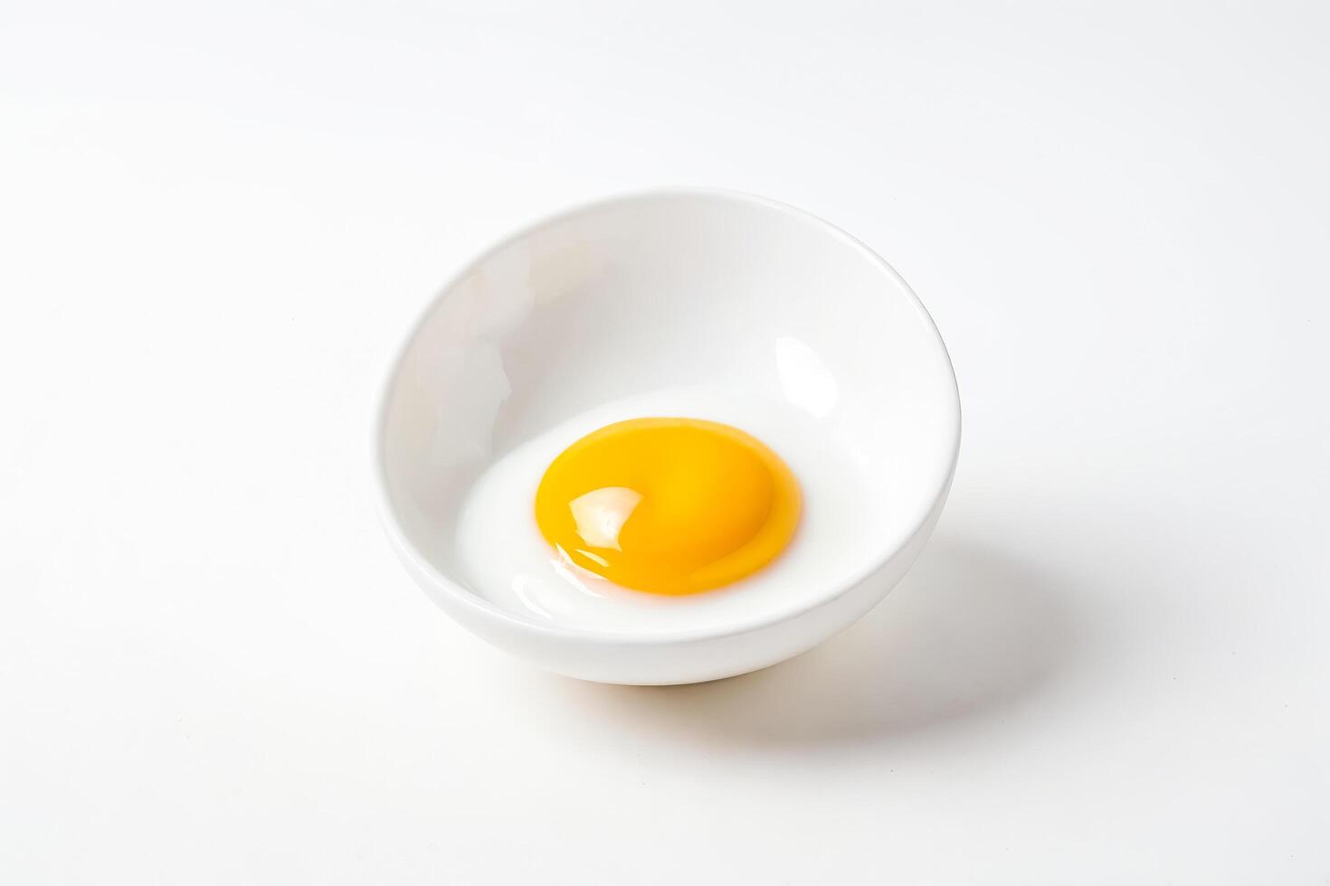 Raw Egg Yolk in White Bowl photo