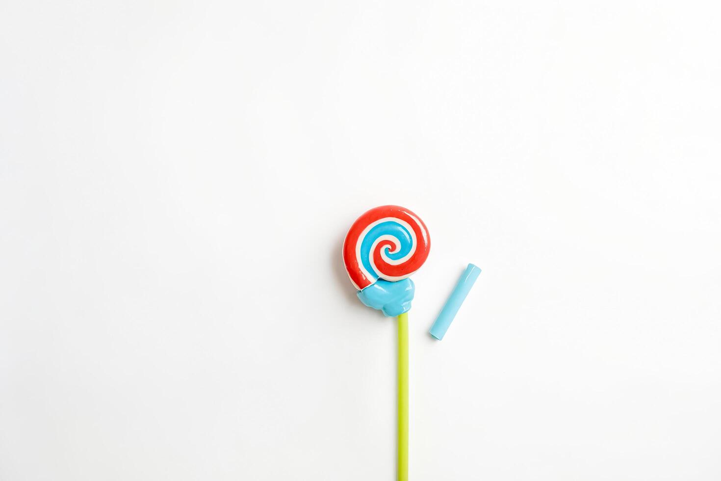 Colorful lollipop with stick and a straw on white background photo