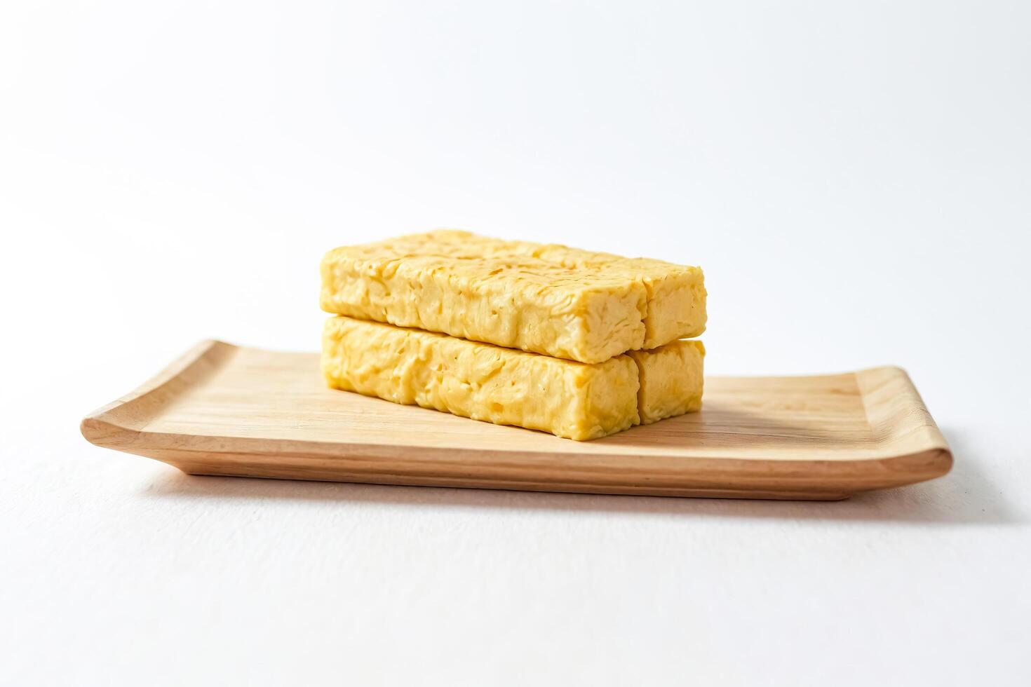 Stack of golden egg omelets on a wooden tray photo