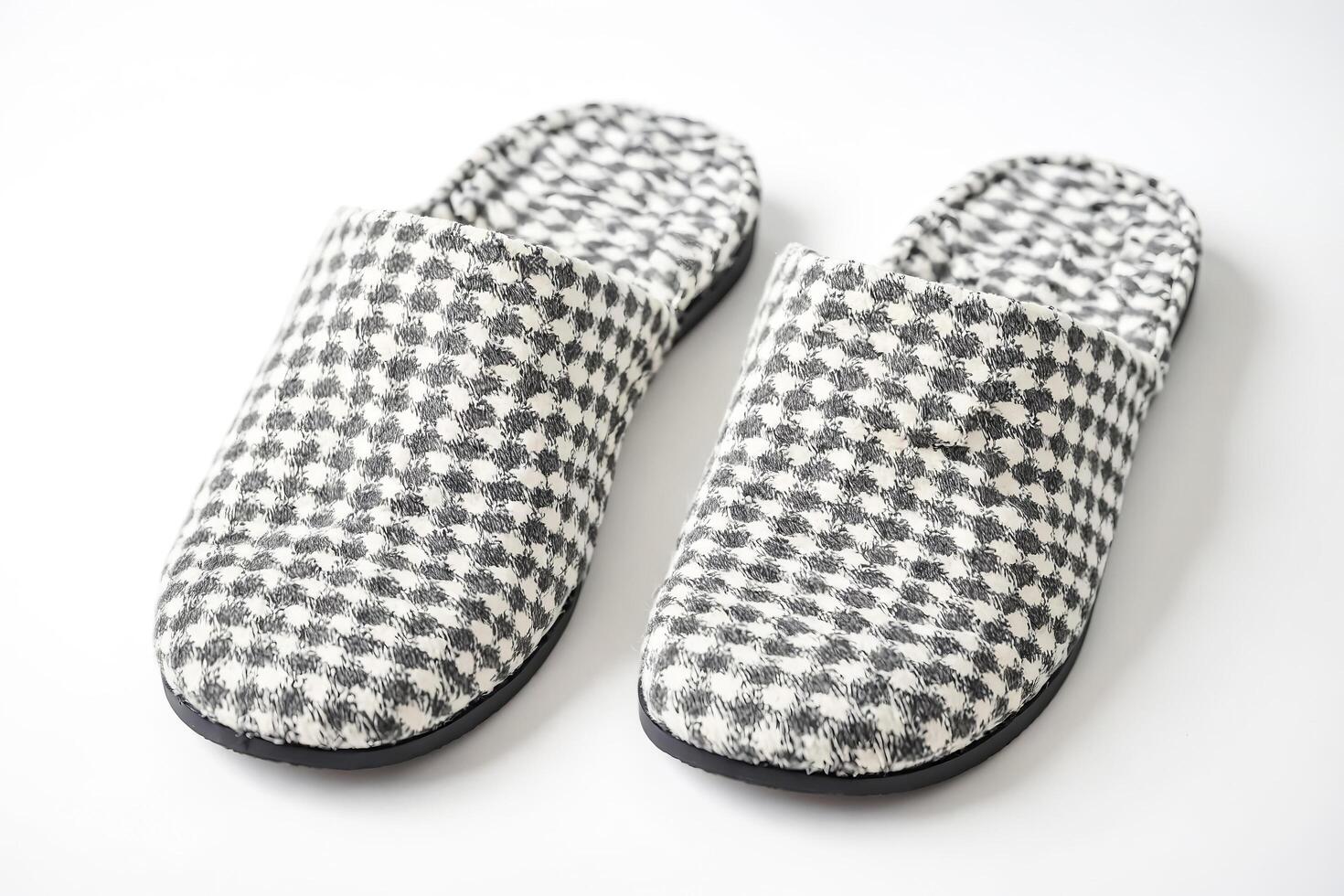 Pair of white and black checkered slippers on white background photo