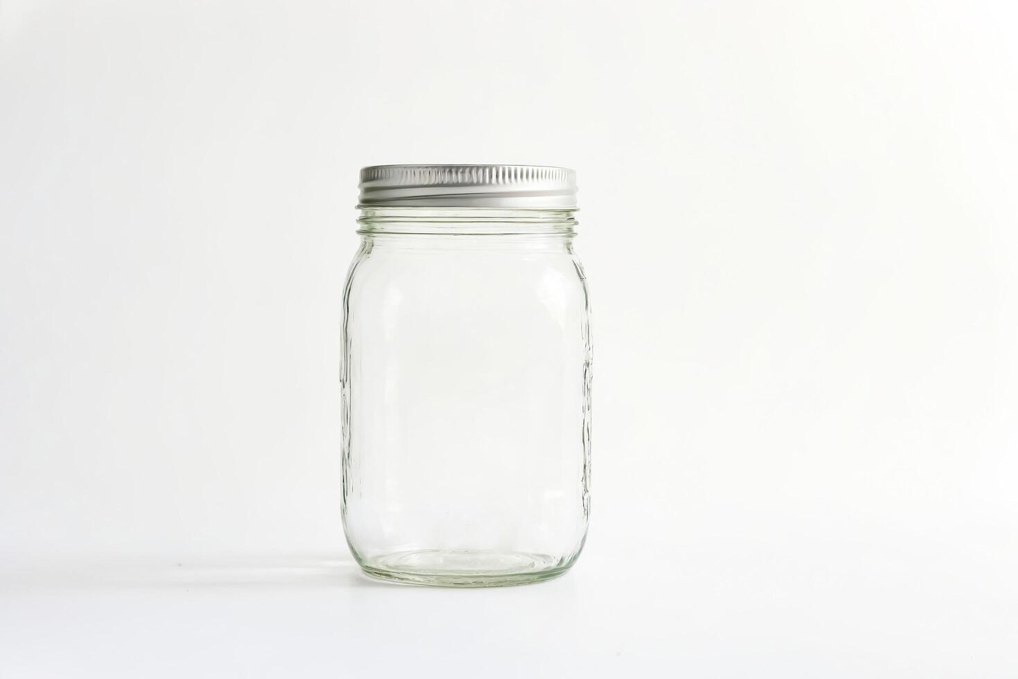 Empty Glass Jar with Silver Lid on White Background photo