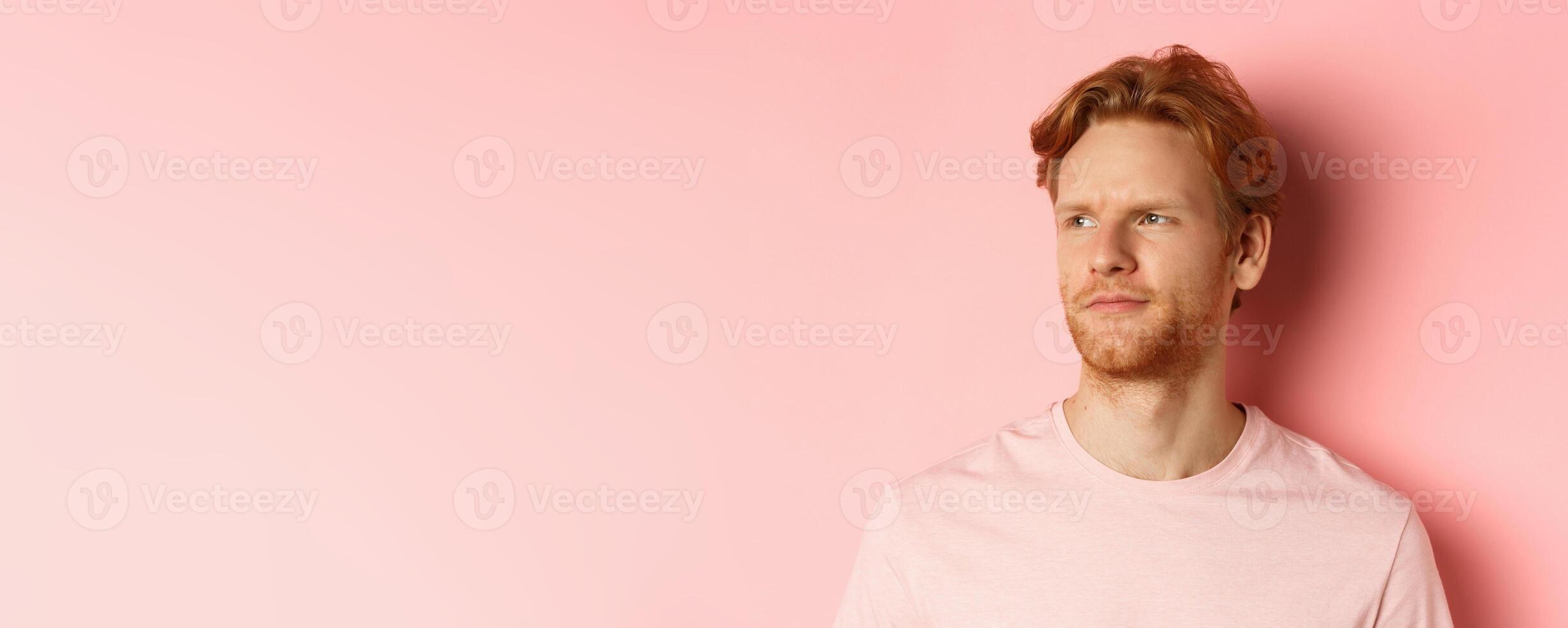 Close up of skeptical and unamused european man, smirk with judgemental face, looking left at banner, standing over pink background photo