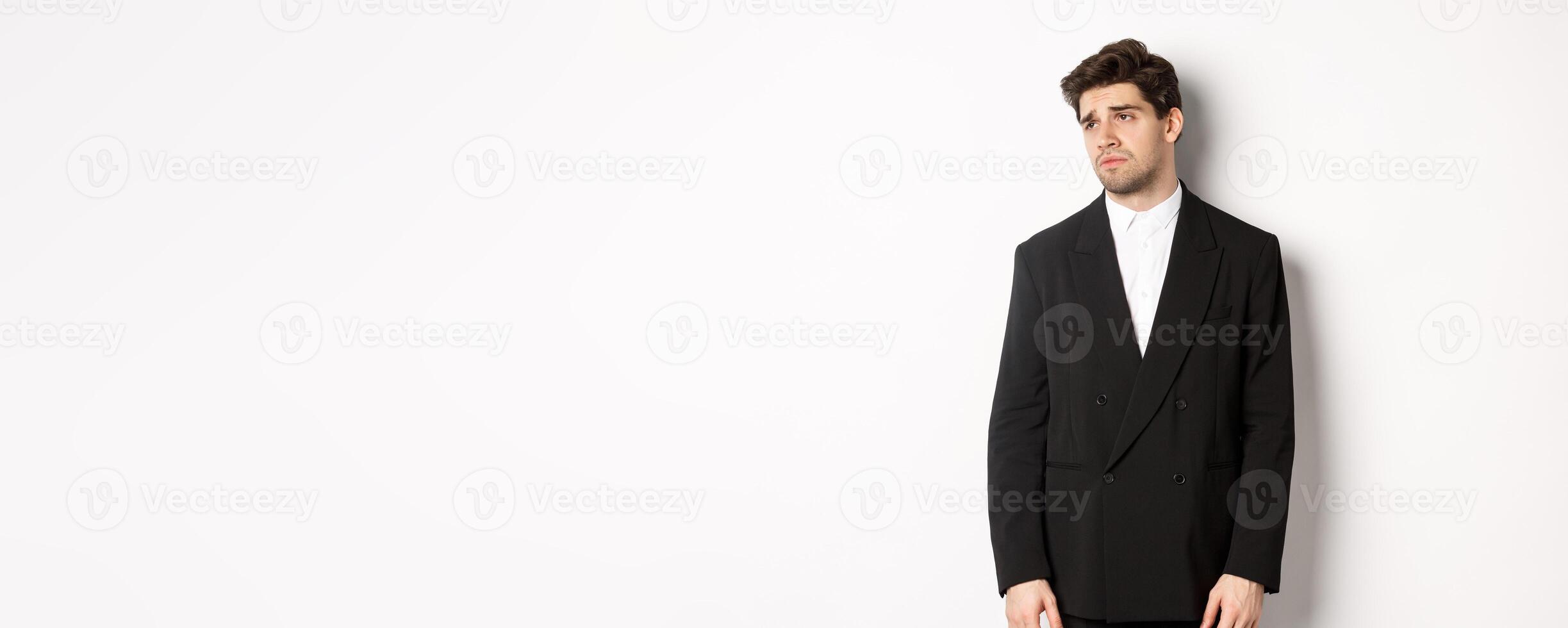 Image of tired man in suit looking left with distressed, gloomy expression, stare left at copy space, standing exhausted over white background photo