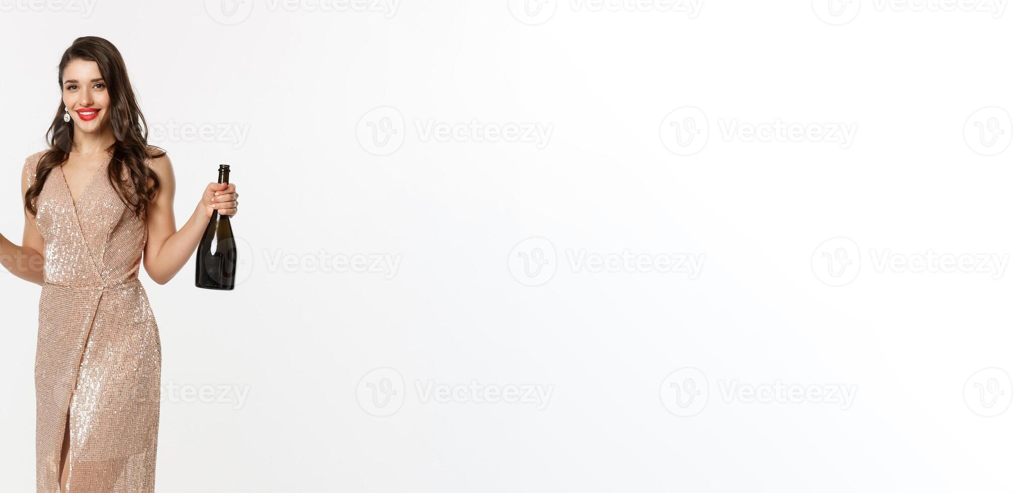 Christmas party and celebration concept. Full length of elegant woman with red lips, luxury dress, holding glass of champagne and bottle, white background photo