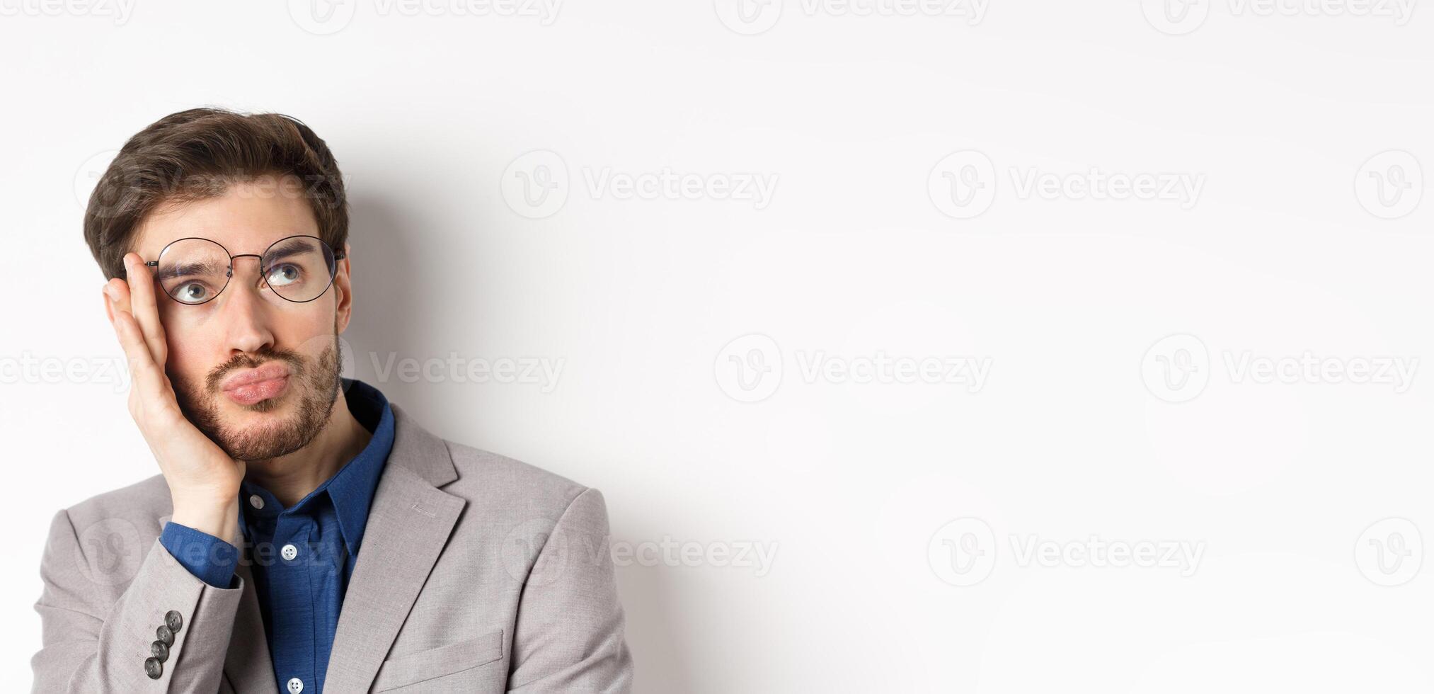 Close-up of shocked tired office worker takes-off glasses and stare at upper right corner with sad face, white background photo