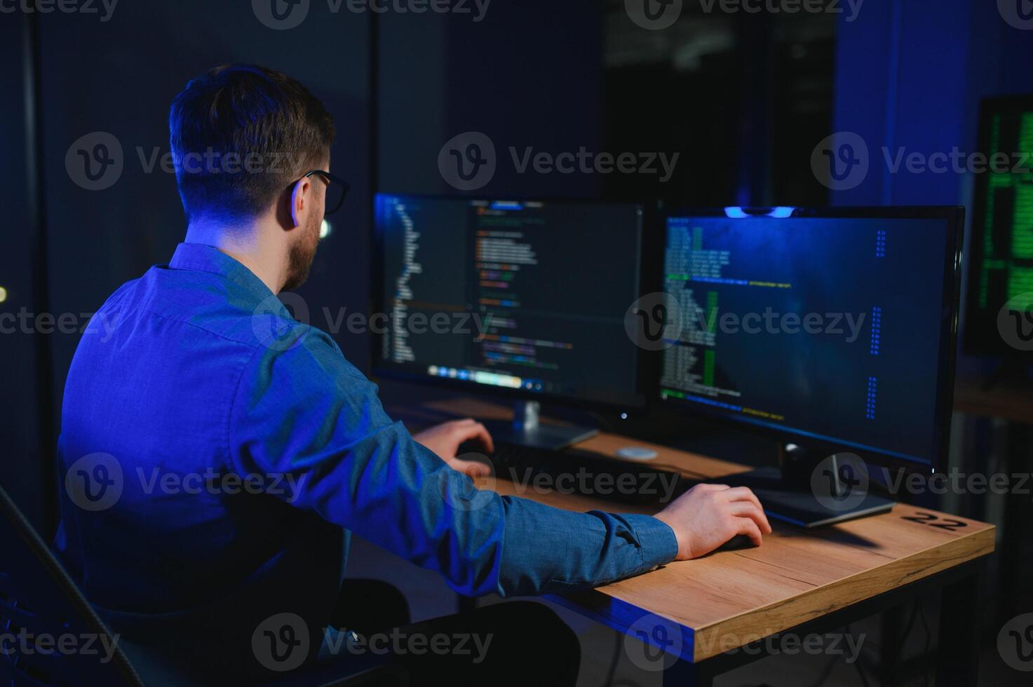 Male programmer working on desktop computer at white desk in office photo
