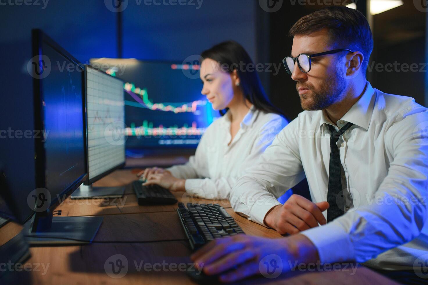 Team of traders working at monitor computer and browsing online in trading office photo