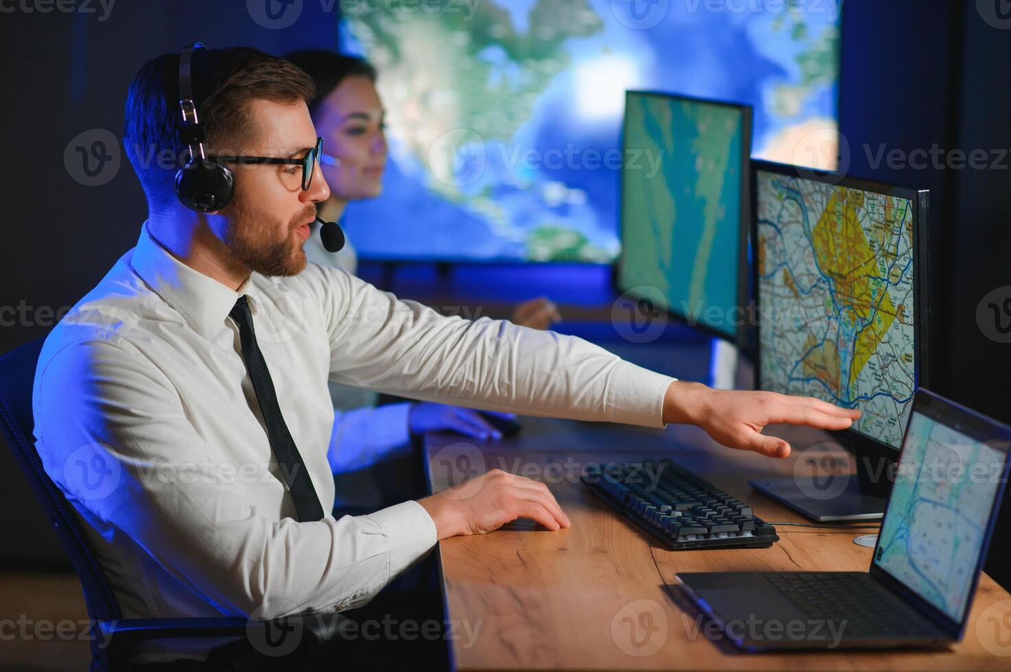 Male Data Scientist Works on Personal Computer Control and Monitoring Room. Map Surveillance of People Walking on City Streets photo