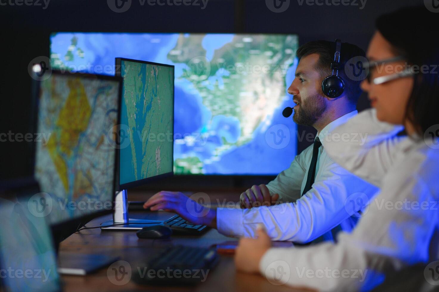 Center of dispatching maintenance. Portrait of cheerful woman and man working via headset microphone while sitting on navigation controller board photo