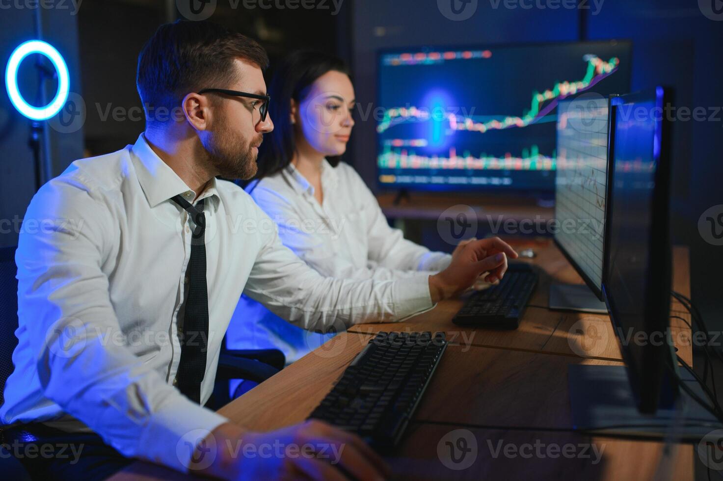 Team of traders working at monitor computer and browsing online in trading office photo
