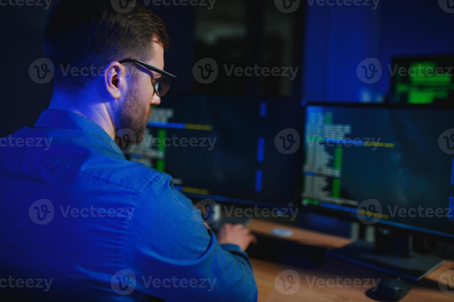 Male programmer working on desktop computer at white desk in office photo