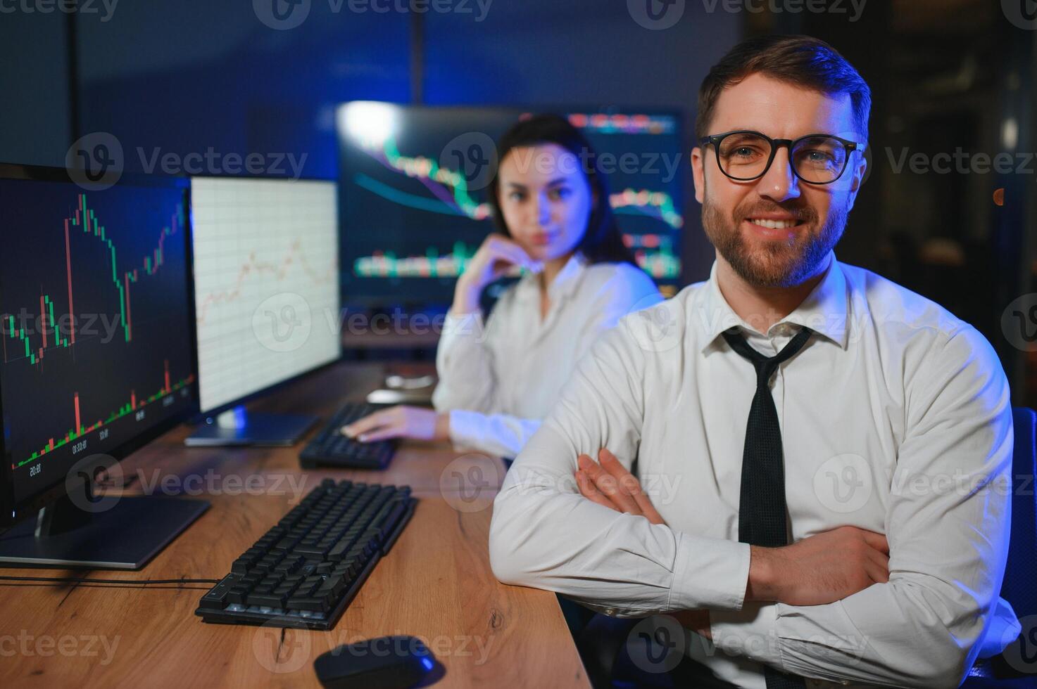 Team of stockbrokers are having a conversation in a dark office with display screens photo