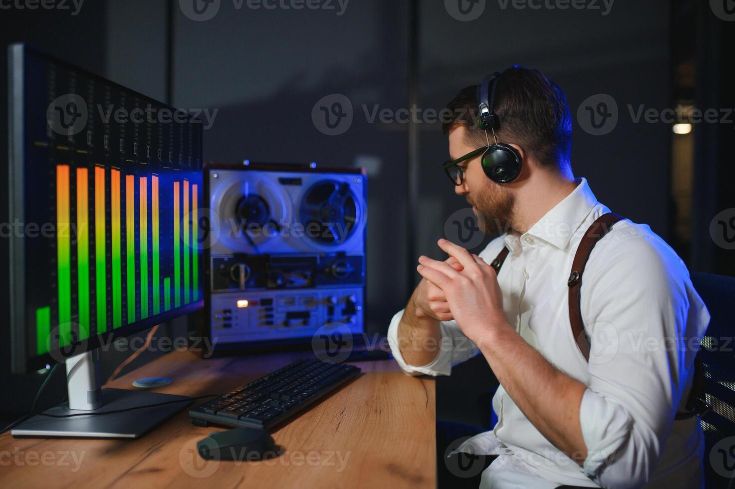 A male spy listens and records conversations on a reel-to-reel tape recorder photo