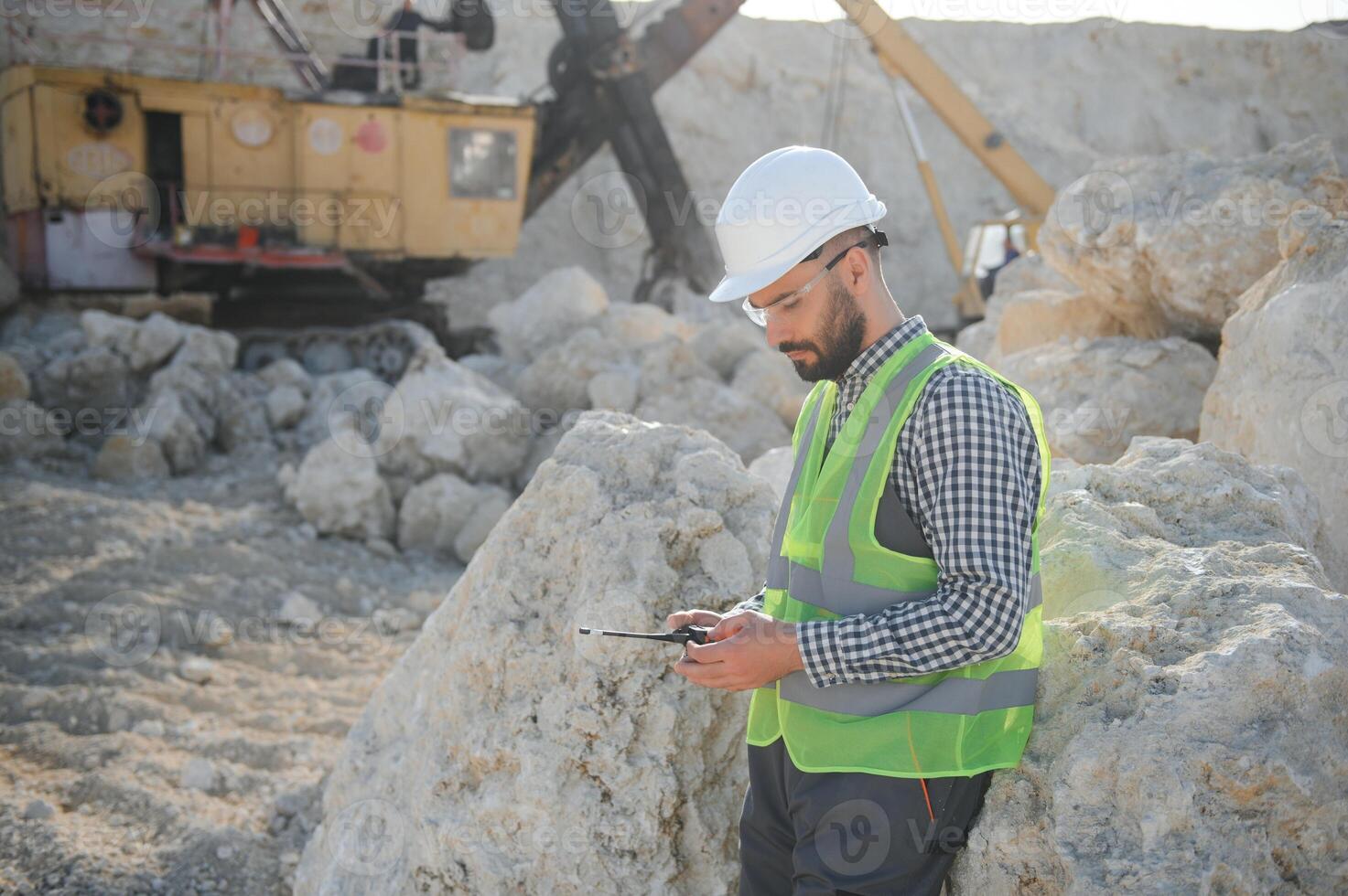 Extraction of stone. Male worker next to stone quarry. Engineer at construction site photo