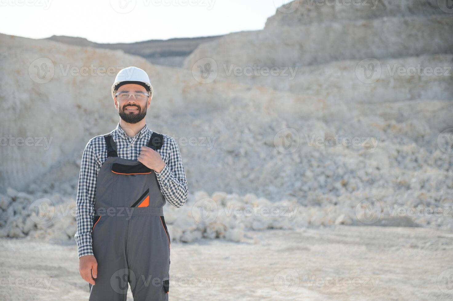 Extraction of stone. Male worker next to stone quarry. Engineer at construction site photo