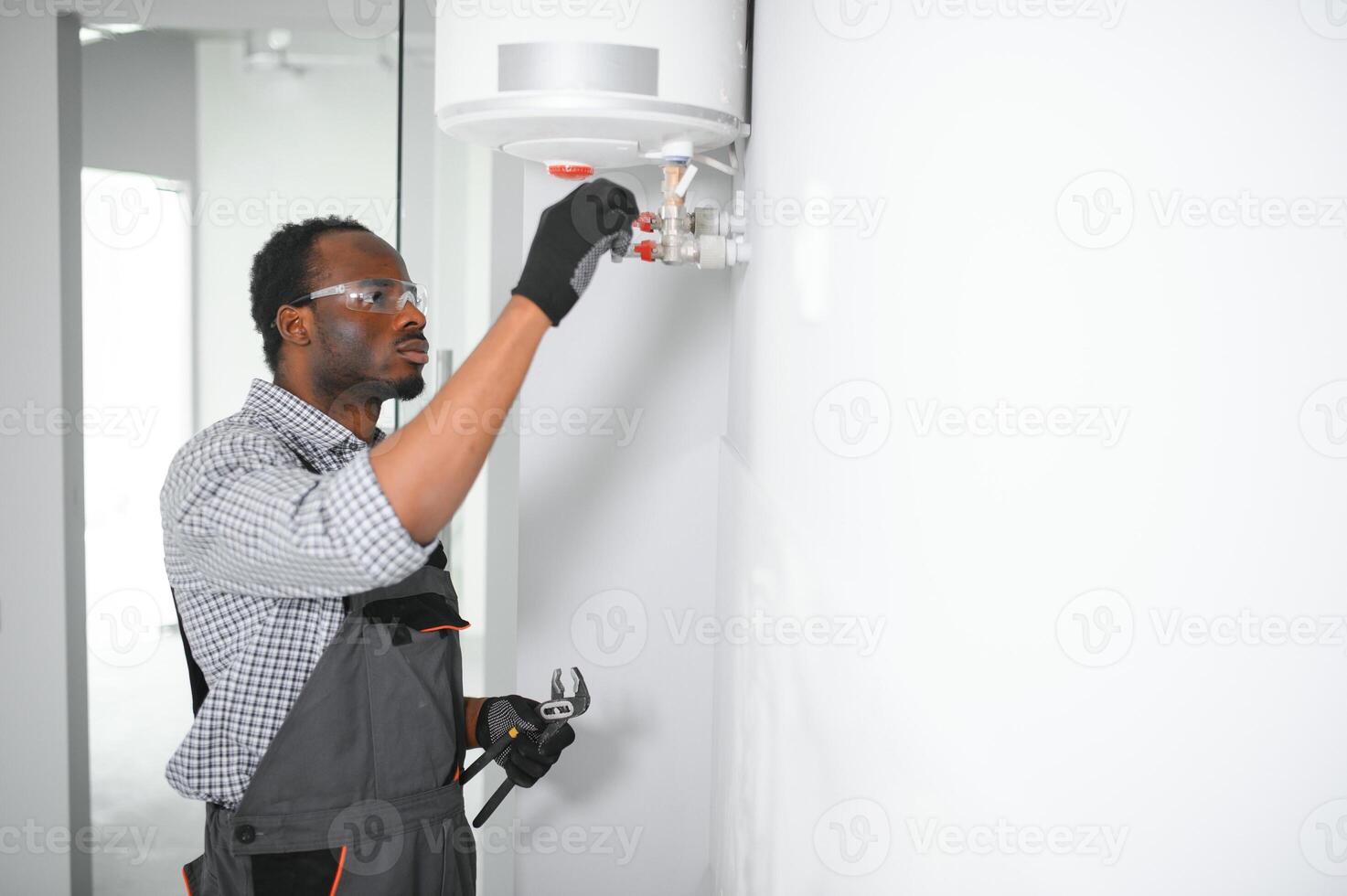Professional african american engineer doing a boiler inspection at home photo