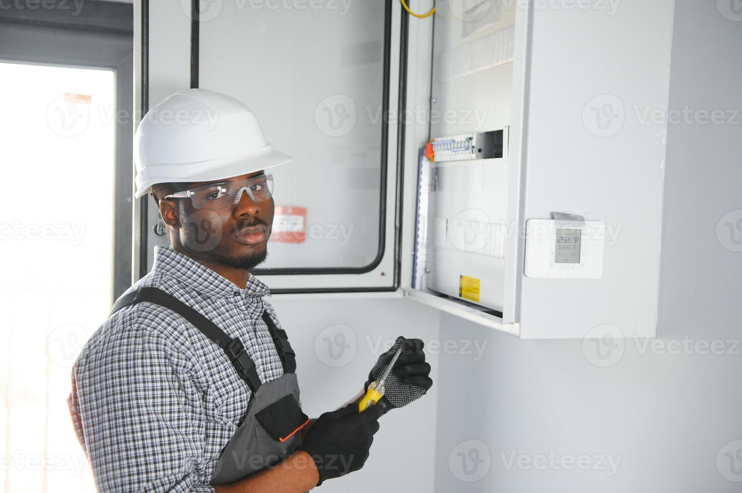 African american electrician Repairing electricity switchboard photo