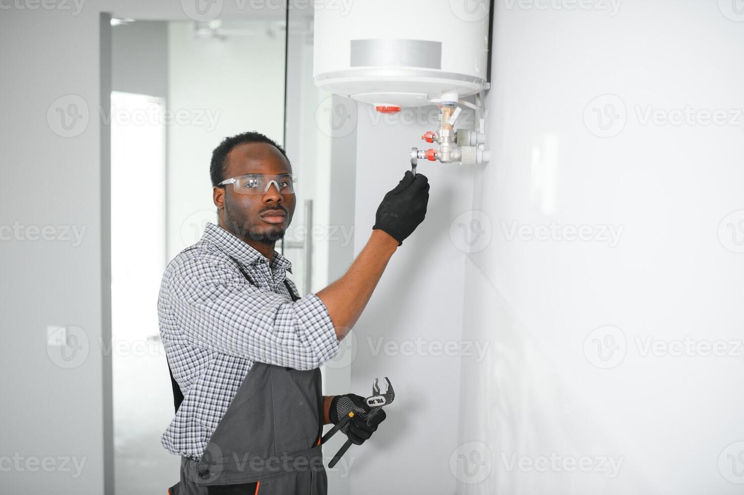 Professional african american engineer doing a boiler inspection at home photo