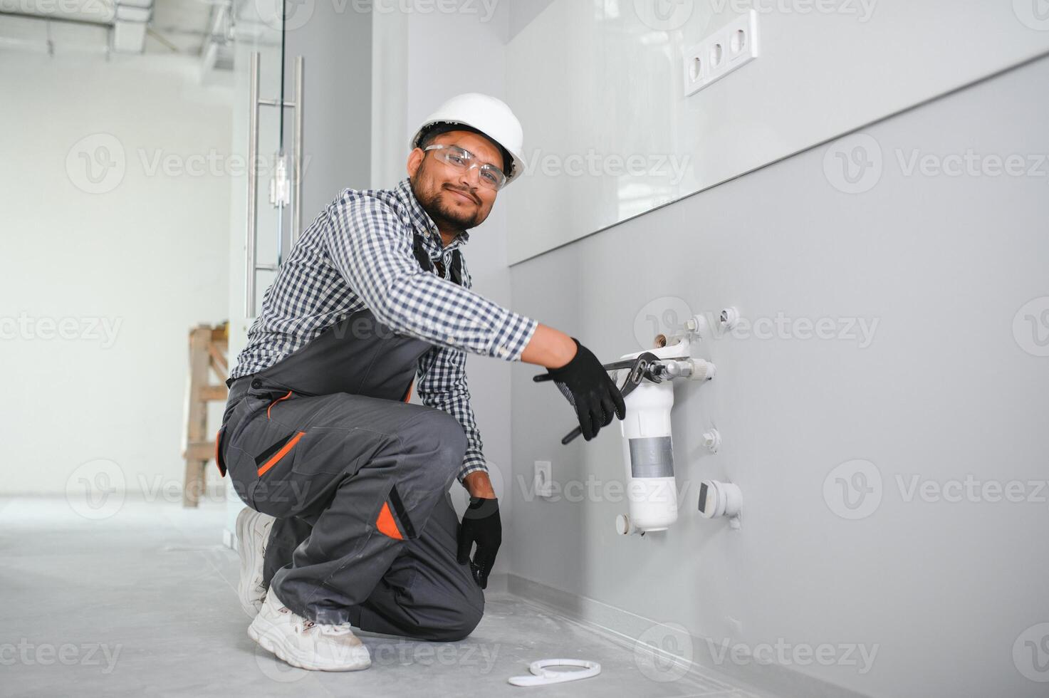 plumber installing water equipment - meter, filter and pressure reducer photo
