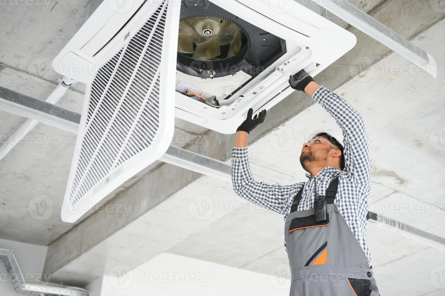 specialist cleans and repairs the wall air conditioner photo