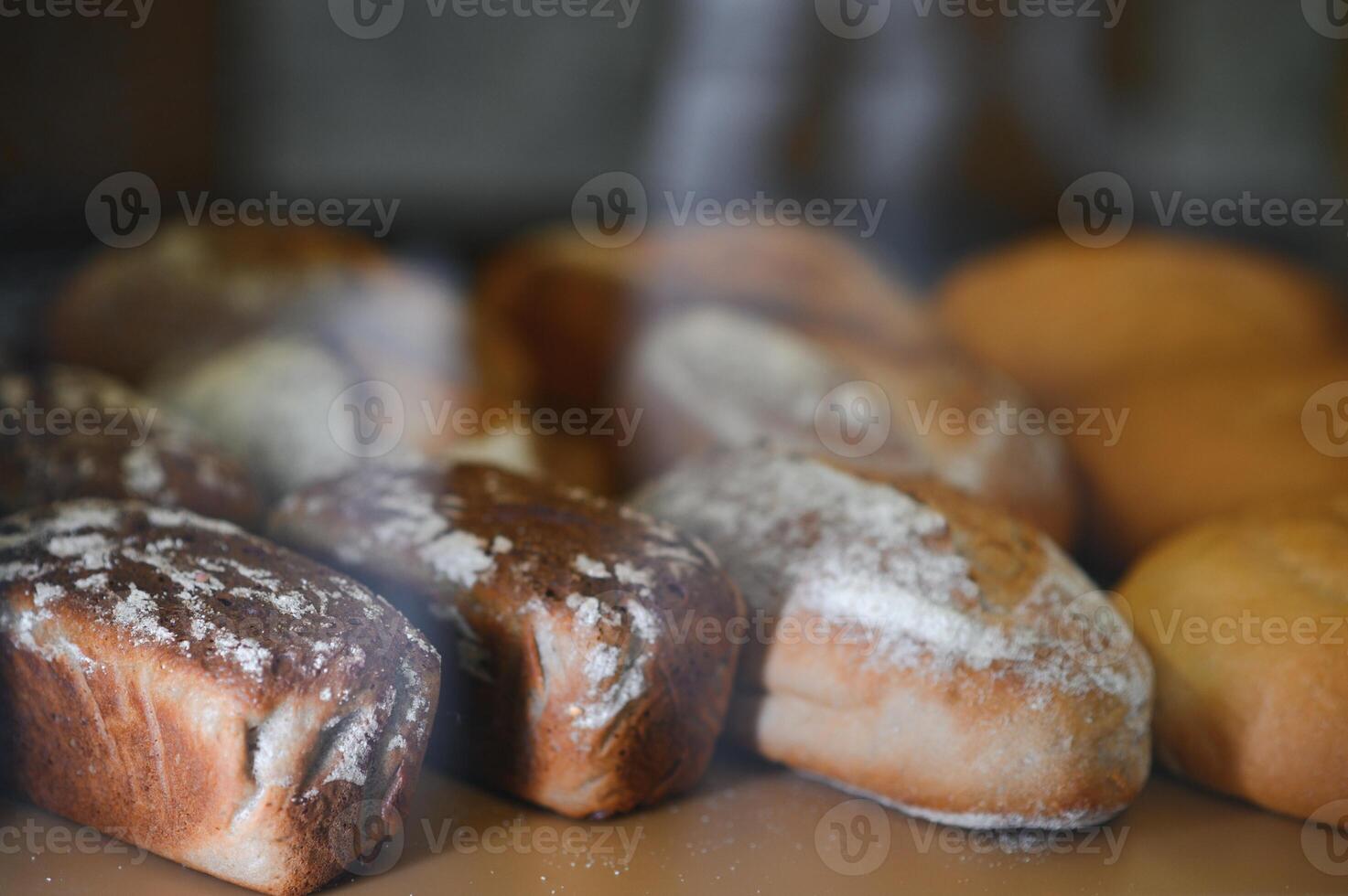 Freshly baked sourdough bread with a golden crust on bakery shelves. Baker shop context with delicious bread photo