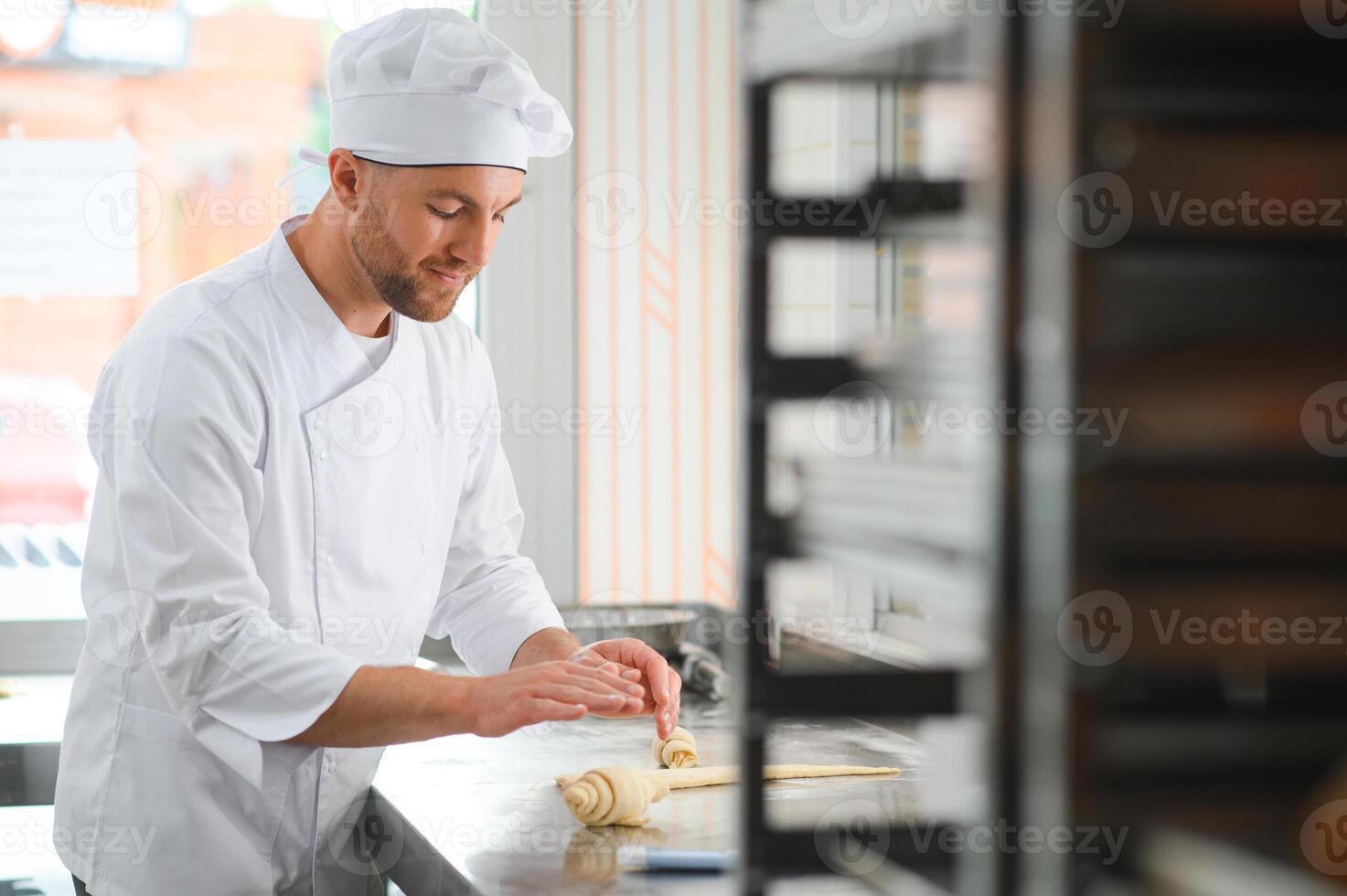pastry chef making some croissant in the bakery photo