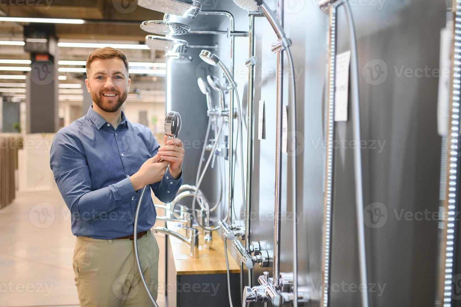 Selects a shower faucet. Man chooses a products in a sanitary ware store photo