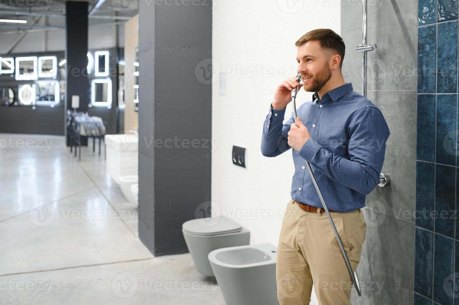Selects a shower faucet. Man chooses a products in a sanitary ware store photo