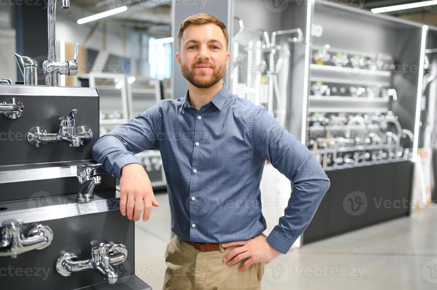 A large selection of water faucets. Man chooses a products in a sanitary ware store photo