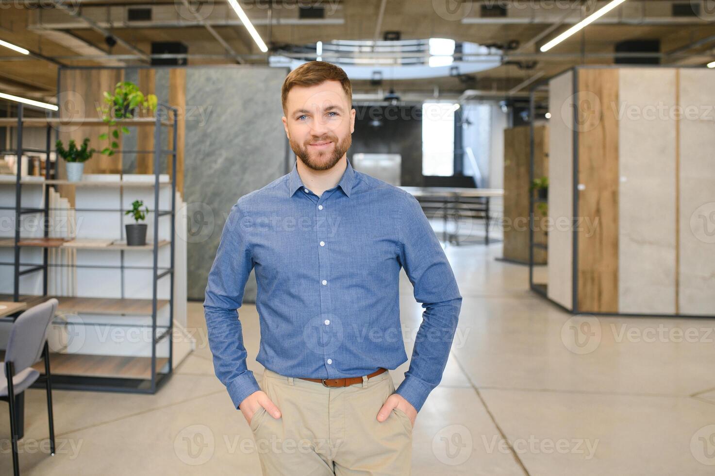 Portrait of a ceramic tile seller. The seller stands against the background of a large assortment of tiles photo